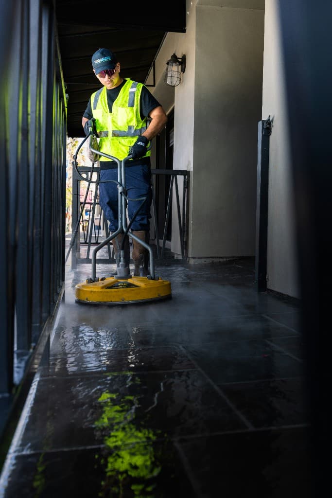 UrbanMove Removals Man and Van Cleaning Services Ltd cleaner using industrial floor equipment on an outdoor walkway in Aberdeen